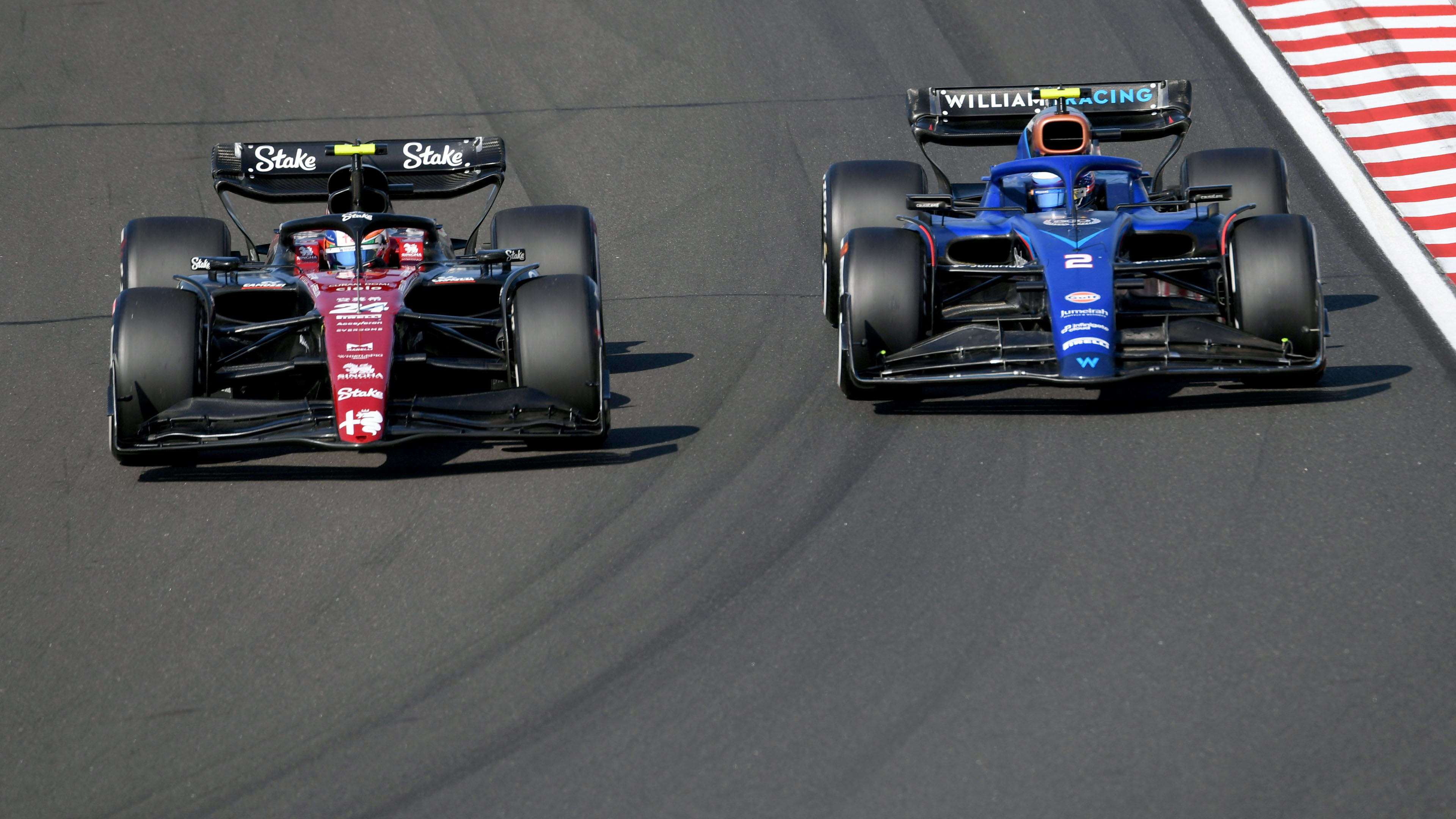 Alfa Romeo's Chinese driver Zhou Guanyu (L) and Williams' US driver Logan Sargeant compete during